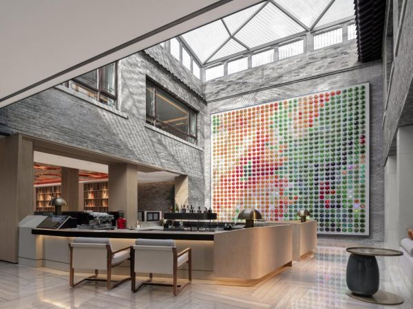 Hotel lobby featuring a large mural on the wall, creating an inviting and artistic atmosphere for guests.